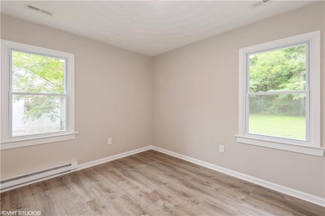 105 Fairfield Ave, Suffolk, VA 23434 - spare room featuring a baseboard radiator, light wood-type flooring, and healthy amount of natural light