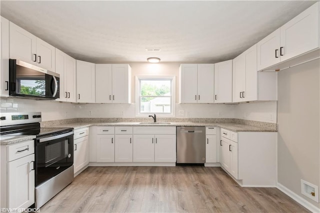 105 Fairfield Ave, Suffolk, VA 23434 - kitchen with stainless steel appliances, light wood-style flooring, white cabinets, and backsplash