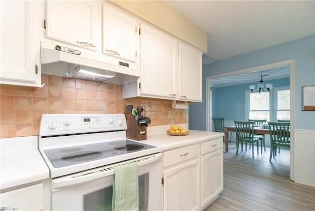 2405 Broadnax Cir, Chesapeake, VA 23323 - kitchen featuring white range with electric cooktop, under cabinet range hood, a chandelier, white cabinets, and light countertops