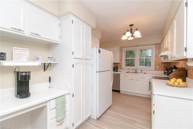 2405 Broadnax Cir, Chesapeake, VA 23323 - kitchen with freestanding refrigerator, under cabinet range hood, white cabinets, and stainless steel dishwasher
