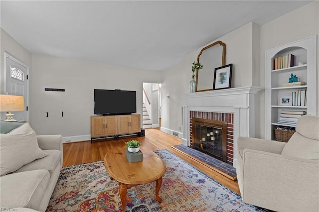 300 N Shore Rd, Norfolk, VA 23505 - living room featuring wood finished floors, a fireplace, built in features, and stairs
