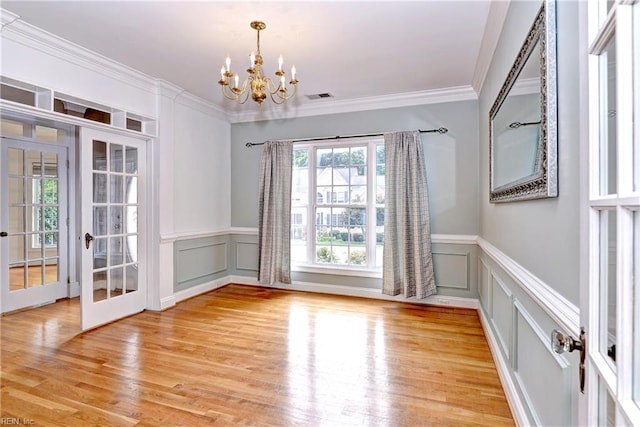 3248 Windsor Rdg, Williamsburg, VA 23188 - unfurnished dining area with a chandelier, a decorative wall, wainscoting, french doors, and crown molding