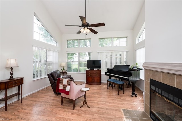 5088 Heathglen Cir, Virginia Beach, VA 23456 - living area with high vaulted ceiling, light wood-style floors, a ceiling fan, and a tiled fireplace