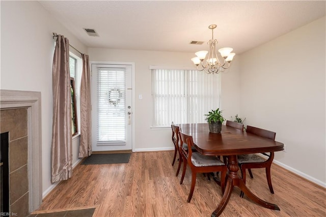 5088 Heathglen Cir, Virginia Beach, VA 23456 - dining area with a chandelier, wood finished floors, and a tiled fireplace