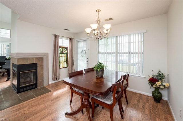 5088 Heathglen Cir, Virginia Beach, VA 23456 - dining area featuring a chandelier, plenty of natural light, wood finished floors, and a tiled fireplace