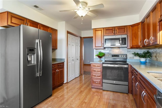 1121 Millay Ct, Virginia Beach, VA 23454 - kitchen featuring appliances with stainless steel finishes, a ceiling fan, light wood-style flooring, and tasteful backsplash