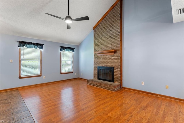 1121 Millay Ct, Virginia Beach, VA 23454 - unfurnished living room featuring lofted ceiling, a textured ceiling, ceiling fan, wood finished floors, and a fireplace