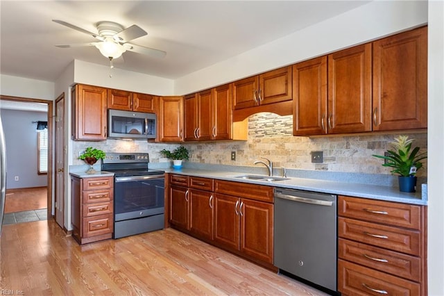 1121 Millay Ct, Virginia Beach, VA 23454 - kitchen featuring appliances with stainless steel finishes, a ceiling fan, light countertops, light wood-style floors, and decorative backsplash
