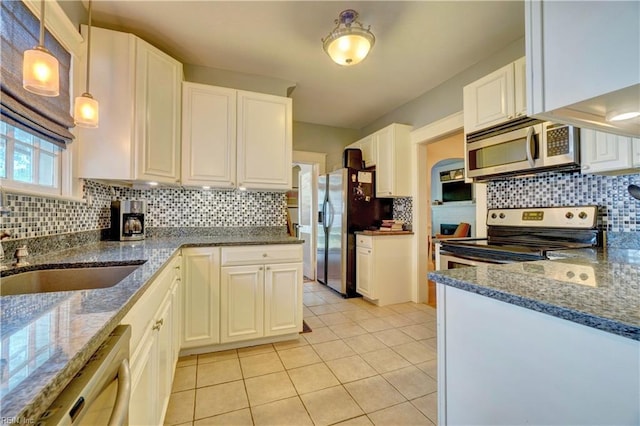 1357 Buckingham Ave, Norfolk, VA 23508 - kitchen featuring stainless steel appliances, decorative backsplash, dark stone counters, light tile patterned floors, and white cabinets