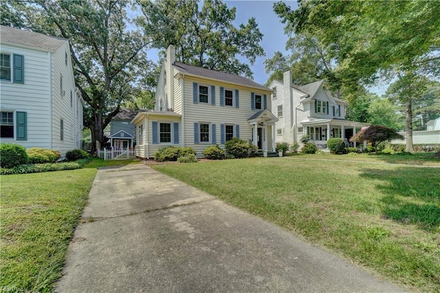 1357 Buckingham Ave, Norfolk, VA 23508 - colonial home featuring concrete driveway, a chimney, and a front lawn