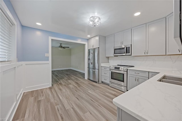 3332 Lusk St, Virginia Beach, VA 23464 - kitchen with stainless steel appliances, light stone counters, light wood finished floors, decorative backsplash, and wainscoting