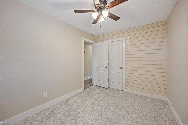 3332 Lusk St, Virginia Beach, VA 23464 - unfurnished bedroom with light carpet, wood walls, ceiling fan, and a closet
