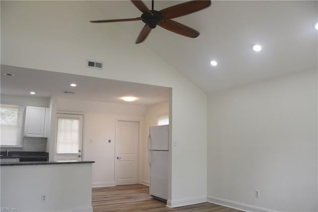 1910 N Lakeland Dr, Norfolk, VA 23518 - kitchen with freestanding refrigerator, dark countertops, a ceiling fan, light wood-style flooring, and white cabinets