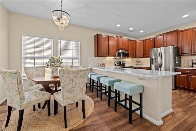13299 Regent Park Walk, Carrollton, VA 23314 - kitchen featuring stainless steel appliances, a kitchen breakfast bar, dark wood-type flooring, a chandelier, and light countertops