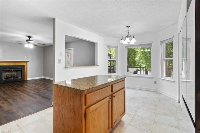 114 Lancelot Dr, Suffolk, VA 23434 - kitchen with a textured ceiling, a chandelier, dark stone countertops, ceiling fan, and light tile patterned floors