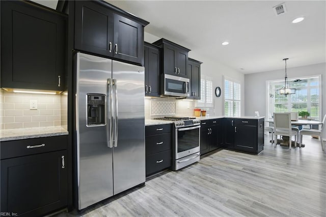 1041 Whitburn Ter, Chesapeake, VA 23322 - kitchen with stainless steel appliances, dark cabinetry, light wood-style flooring, tasteful backsplash, and recessed lighting