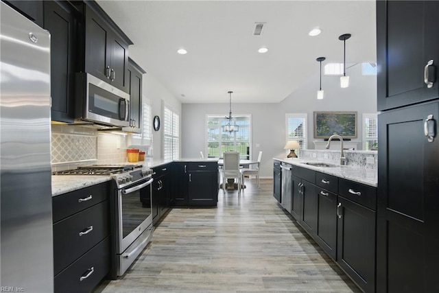 1041 Whitburn Ter, Chesapeake, VA 23322 - kitchen featuring stainless steel appliances, a peninsula, dark cabinets, light wood finished floors, and recessed lighting