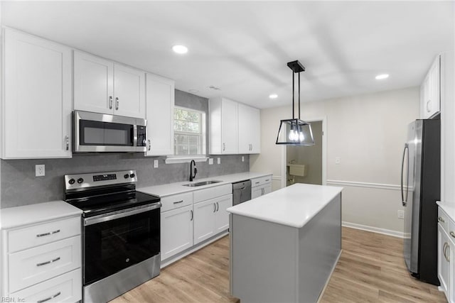 2001 Blackwell Ct, Virginia Beach, VA 23464 - kitchen featuring appliances with stainless steel finishes, a center island, light wood-style floors, tasteful backsplash, and white cabinets