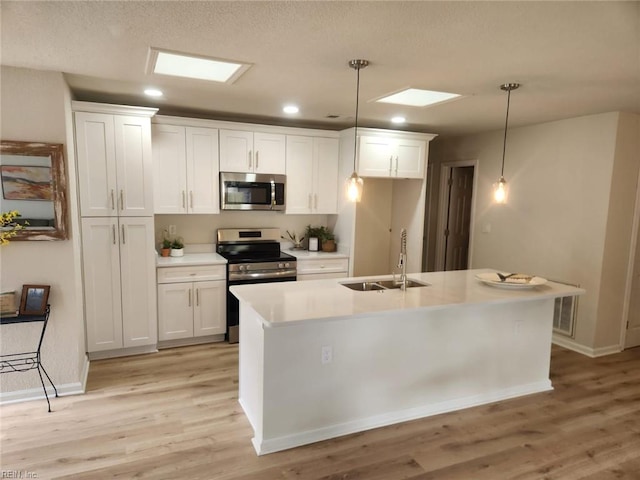 13031 Green Grove Ln, Newport News, VA 23608 - kitchen with appliances with stainless steel finishes, white cabinets, light wood-type flooring, hanging light fixtures, and light countertops