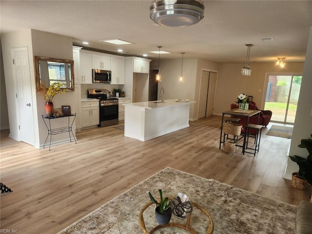 13031 Green Grove Ln, Newport News, VA 23608 - kitchen featuring appliances with stainless steel finishes, white cabinets, light wood-type flooring, light countertops, and recessed lighting