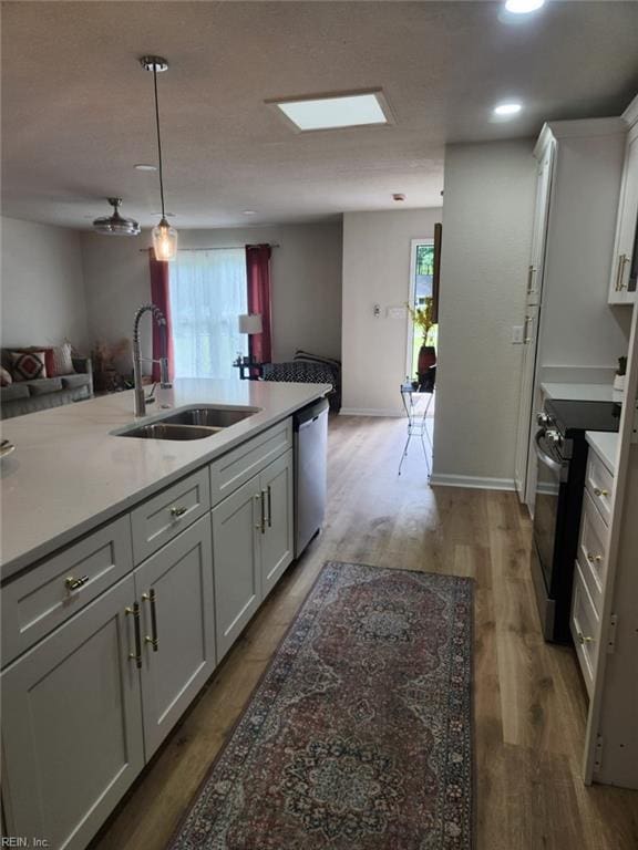 13031 Green Grove Ln, Newport News, VA 23608 - kitchen featuring stainless steel appliances, open floor plan, light countertops, white cabinets, and light wood finished floors