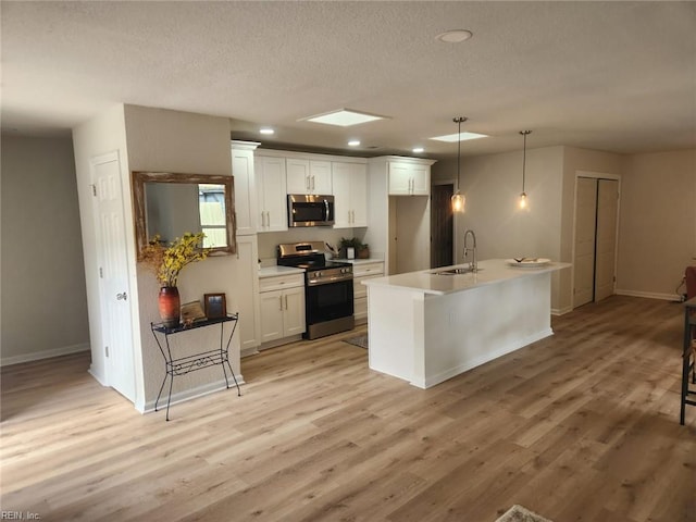 13031 Green Grove Ln, Newport News, VA 23608 - kitchen featuring stainless steel appliances, white cabinets, recessed lighting, a textured ceiling, and light wood-type flooring