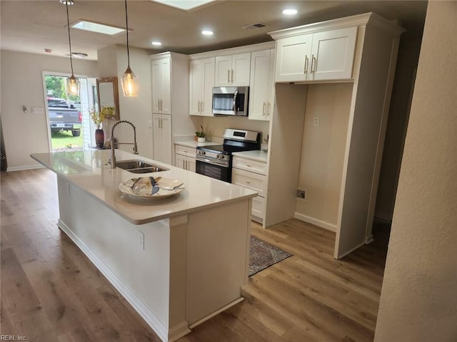 13031 Green Grove Ln, Newport News, VA 23608 - kitchen with appliances with stainless steel finishes, white cabinets, light wood-type flooring, a kitchen island with sink, and recessed lighting