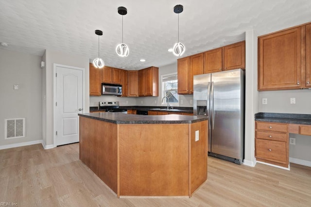 5561 Taylors Walke Ln, Virginia Beach, VA 23462 - kitchen with appliances with stainless steel finishes, dark countertops, light wood-style flooring, and a center island