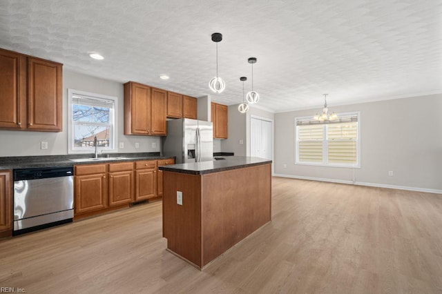 5561 Taylors Walke Ln, Virginia Beach, VA 23462 - kitchen with appliances with stainless steel finishes, dark countertops, brown cabinetry, a chandelier, and light wood-style flooring