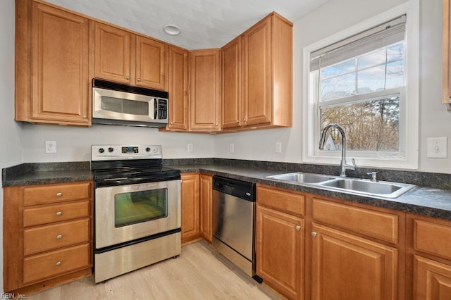5561 Taylors Walke Ln, Virginia Beach, VA 23462 - kitchen with appliances with stainless steel finishes, dark countertops, light wood-style floors, and brown cabinets
