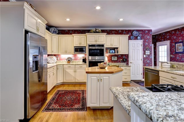 8265 Wrenfield Dr, Williamsburg, VA 23188 - kitchen with stainless steel appliances, wallpapered walls, ornamental molding, butcher block countertops, and light wood finished floors