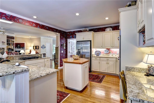8265 Wrenfield Dr, Williamsburg, VA 23188 - kitchen featuring wallpapered walls, stainless steel fridge, crown molding, a center island, and white cabinetry