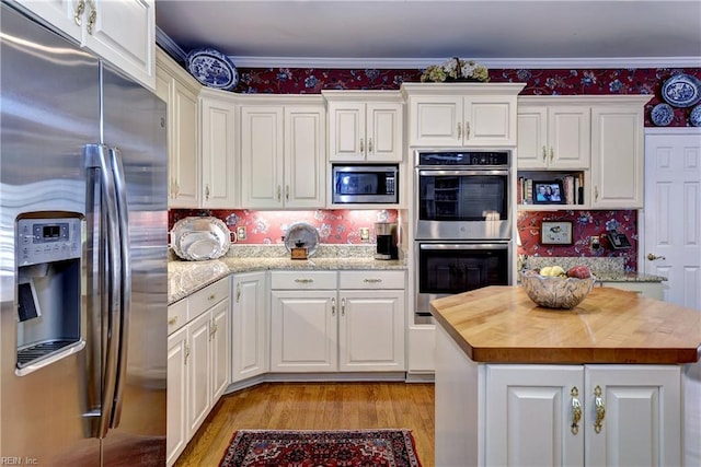 8265 Wrenfield Dr, Williamsburg, VA 23188 - kitchen featuring stainless steel appliances, wooden counters, light wood-style flooring, white cabinetry, and crown molding