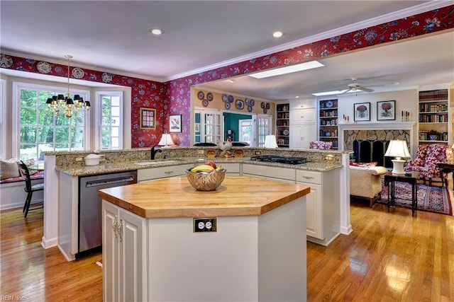 8265 Wrenfield Dr, Williamsburg, VA 23188 - kitchen featuring stainless steel dishwasher, wooden counters, a kitchen island, wallpapered walls, and a stone fireplace