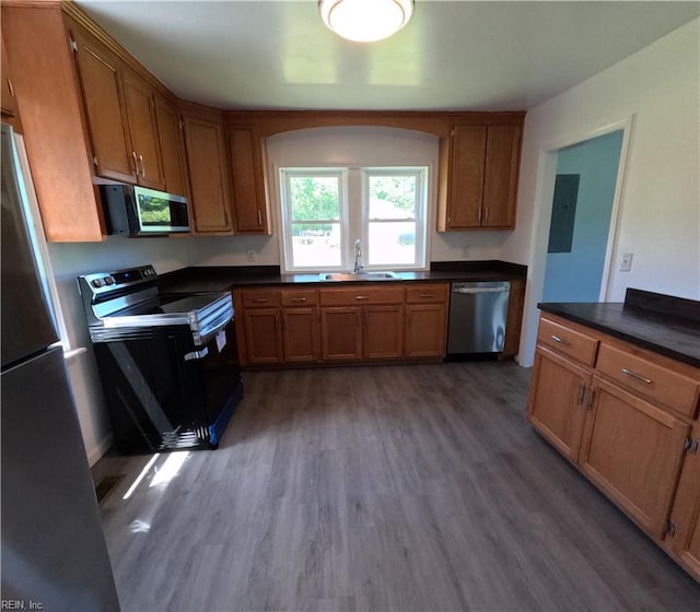 7276 Griffin Rd, Gloucester, VA 23061 - kitchen with appliances with stainless steel finishes, wood finished floors, dark countertops, and brown cabinetry
