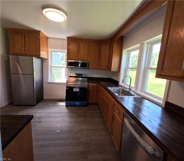 7276 Griffin Rd, Gloucester, VA 23061 - kitchen with appliances with stainless steel finishes, plenty of natural light, dark wood-style floors, and brown cabinets