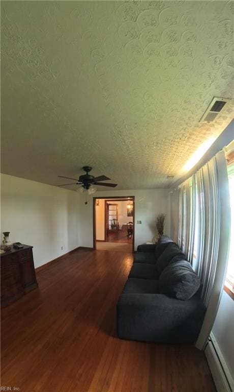 3244 Pruden Blvd, Suffolk, VA 23434 - living room featuring a baseboard heating unit, wood finished floors, a ceiling fan, and a textured ceiling