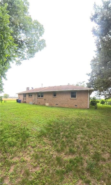 3244 Pruden Blvd, Suffolk, VA 23434 - rear view of house with crawl space, a lawn, a chimney, and brick siding