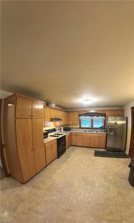 3244 Pruden Blvd, Suffolk, VA 23434 - kitchen featuring stainless steel fridge, gas stove, light countertops, and under cabinet range hood