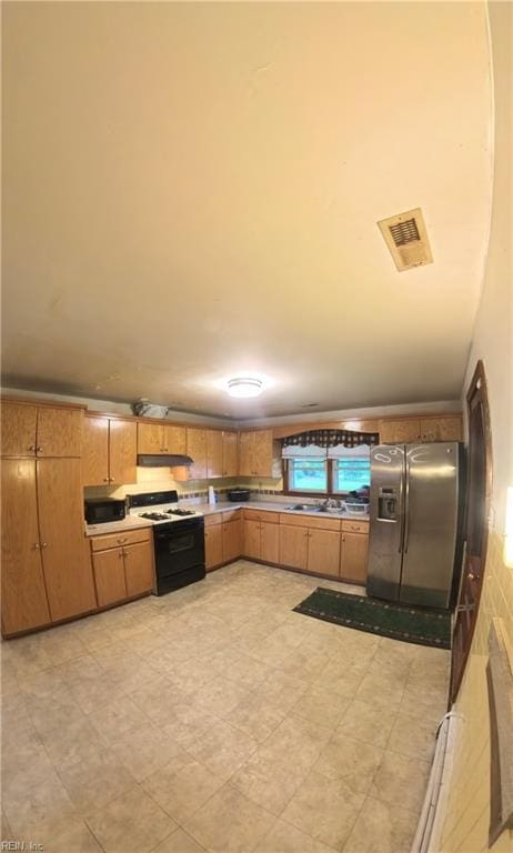 3244 Pruden Blvd, Suffolk, VA 23434 - kitchen with stainless steel fridge with ice dispenser, range with gas cooktop, under cabinet range hood, light floors, and brown cabinetry