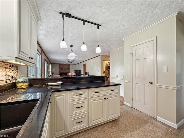 102 Canvasback Trl, Newport News, VA 23602 - kitchen featuring a peninsula, a textured ceiling, dark countertops, hanging light fixtures, and stacked washer / drying machine