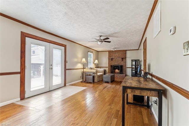 102 Canvasback Trl, Newport News, VA 23602 - living area featuring french doors, ceiling fan, light wood-style flooring, a fireplace, and crown molding
