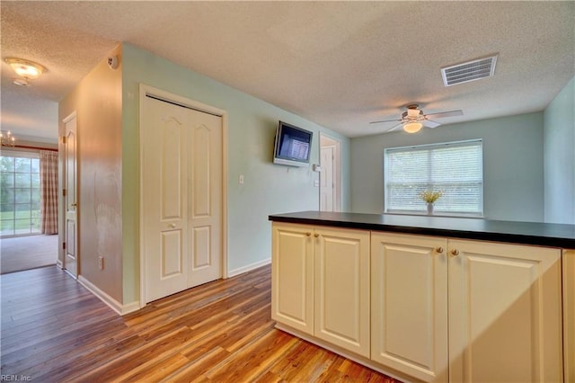 307 Melrose Ct, Suffolk, VA 23434 - kitchen featuring a textured ceiling, dark countertops, light wood-style flooring, ceiling fan, and white cabinetry