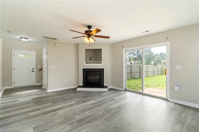 102 Sonoma Ct, Williamsburg, VA 23185 - unfurnished living room with wood finished floors, a glass covered fireplace, and a ceiling fan