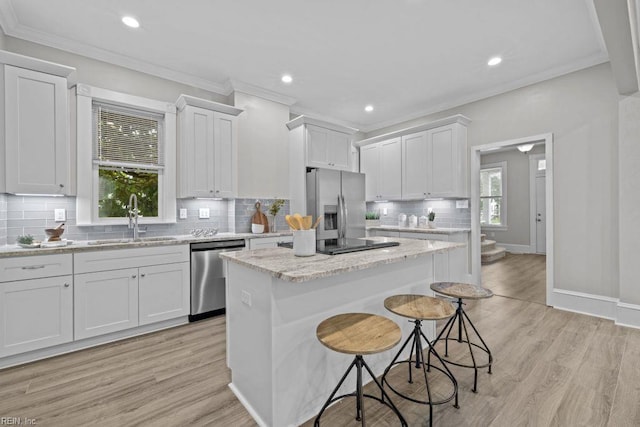 2233 Keller Ave, Norfolk, VA 23509 - kitchen featuring appliances with stainless steel finishes, a center island, a breakfast bar, backsplash, and crown molding