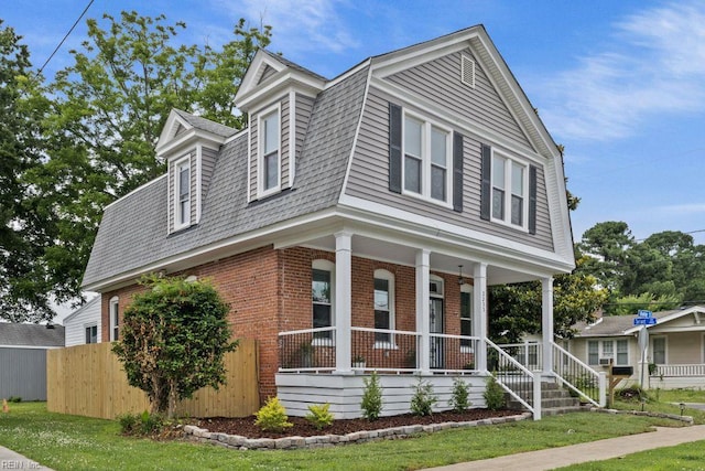 2233 Keller Ave, Norfolk, VA 23509 - view of front of property with brick siding, a porch, a gambrel roof, and a shingled roof