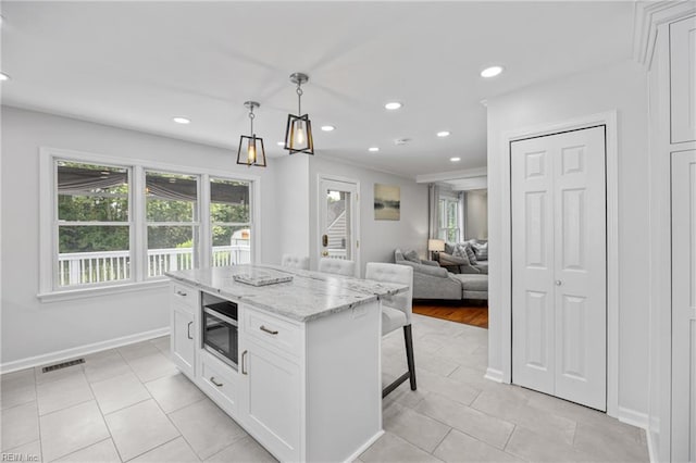 929 Magnolia Ave, Norfolk, VA 23508 - kitchen with white cabinetry, light tile patterned floors, recessed lighting, a breakfast bar, and pendant lighting