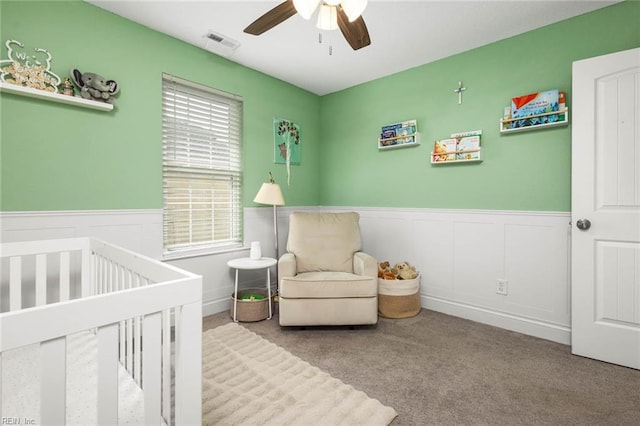 401 W 30th St, Norfolk, VA 23508 - carpeted bedroom with a crib, wainscoting, and a ceiling fan