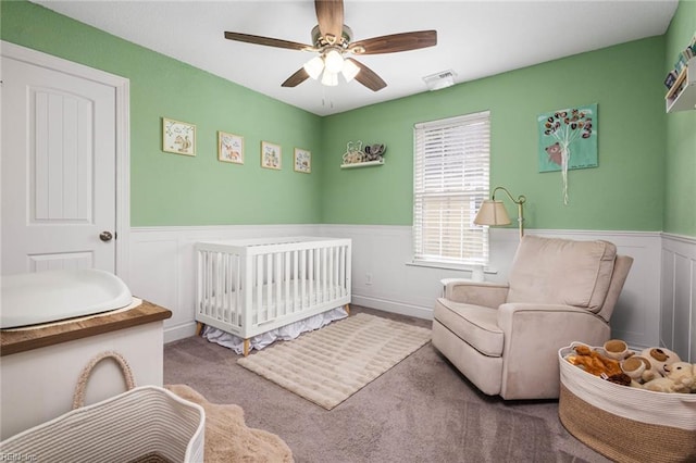 401 W 30th St, Norfolk, VA 23508 - carpeted bedroom featuring a nursery area, a wainscoted wall, a ceiling fan, and a decorative wall