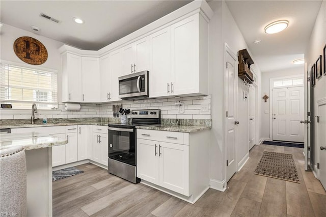 401 W 30th St, Norfolk, VA 23508 - kitchen featuring stainless steel appliances, light wood-style flooring, white cabinets, tasteful backsplash, and recessed lighting